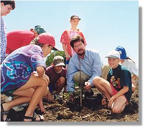 Mayor planting trees with school children on National Tree Day
